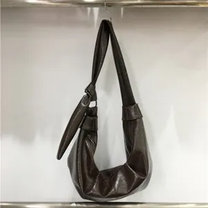 Detailed view of the dark brown soft leather pleated shoulder bag showcasing its unique texture.
