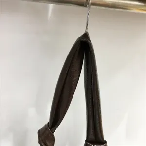 Close up detail view of vintage soft leather pleated dumpling shoulder bag handle and knot.