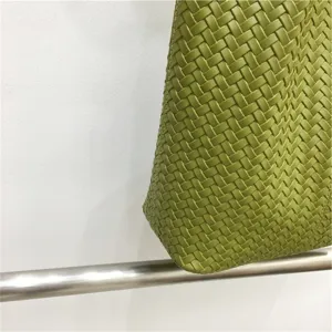 Green woven leather handbag detail shot, stylish shoulder tote bag for summer daily wear.