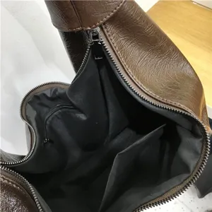Interior detail shot of the brown faux leather hobo dumpling shoulder bag with pockets.