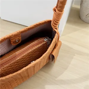 Woven leather shoulder handbag for women, elegant casual underarm bag with knotted handle.