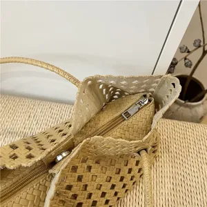 Λεπτομερής κοντινή λήψη κομψής πλεκτής δερμάτινης τσάντας με μεταλλικό φερμουάρ και υφή.