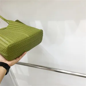 Green woven leather shoulder tote bag detail view, casual summer fashion handbag for daily use.
