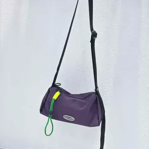 Casual purple nylon crossbody bag with black strap and green cord accent for women.