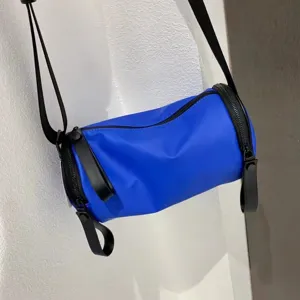 Blue nylon barrel crossbody bag detail, casual cylinder shoulder handbag daily use.