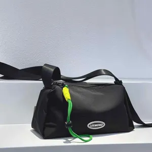 Detail view of black nylon crossbody bag with neon green drawstring and LEEMONO logo patch.