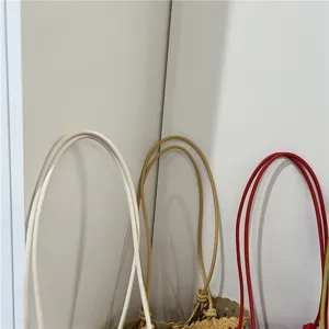 Summer fashion cutout woven bag detail view, soft leather bucket bag handle and woven texture.
