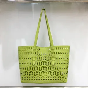 Detail shot of green laser cut geometric pattern tote bag surface and double handles.
