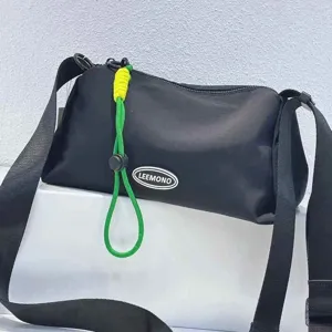 Casual black oxford cloth crossbody bag for women with green drawstring and shoulder strap.