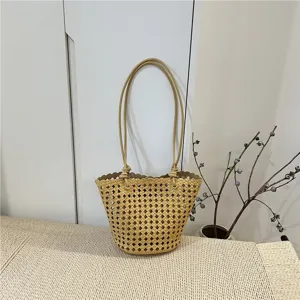 Detailed shot of yellow woven leather bucket bag with top handles, displayed in home scene setting.