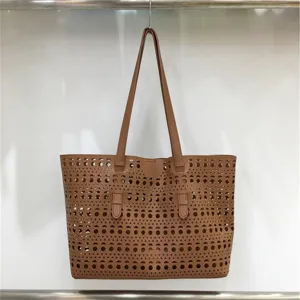 Brown hollow-carved tote bag detailed view, large capacity shoulder handbag with geometric patterns.