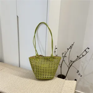 Detail view of the summer fashion hollow woven soft leather bucket bag in vibrant green color.