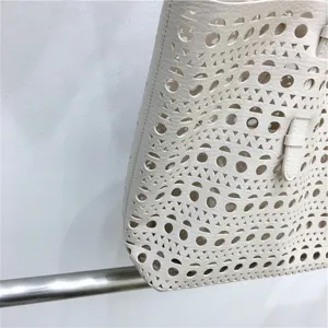 Laser-cut beige leather tote bag detail view, chic handbag for women spring season.