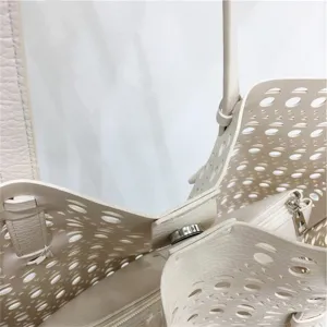 Close-up detail of hollow cutout tote bag interior, shoulder strap and magnetic snap closure.