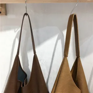 Soft leather slouchy shoulder bag detail shot showing texture and long strap design.