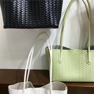 Detailed close-up view of stylish woven leather shoulder tote bags in black, green, and white.