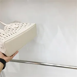 Beige laser cut tote bag detail showing structured bottom and spacious design style.