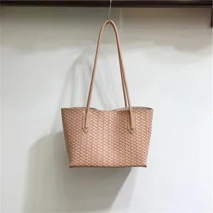 Detailed view of fashionable woven leather shoulder tote bag with soft texture and handles.