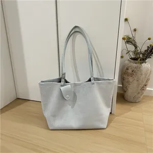 Detailed showcase of soft light blue suede fabric texture and hanging mini charm accessory.