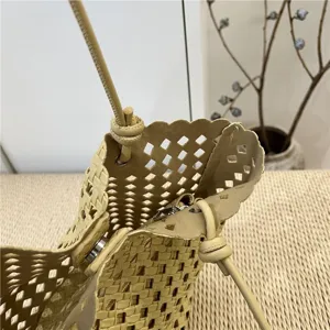 Close-up detail of summer fashion yellow soft leather woven bucket bag with cutout design.