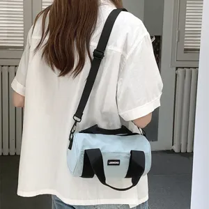 Casual nylon cylindrical shoulder bag for women, lightweight commuter handbag, light blue.