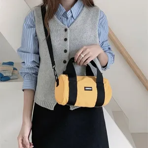 Casual yellow oxford cloth cylindrical crossbody bag with top handle and shoulder strap.