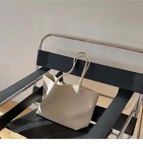 Minimalist beige leather shoulder tote bag detail shot, elegant daily casual handbag.