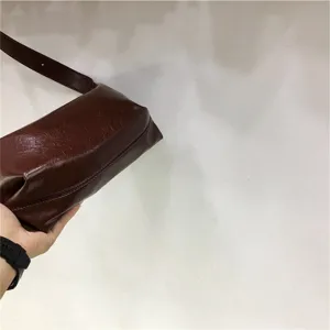 Minimalist soft textured dumpling underarm bag, casual commuter shoulder design for daily wear.