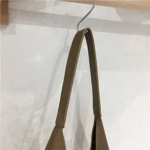 Close-up detail of soft faux leather handbag strap, showing fine stitching and texture.