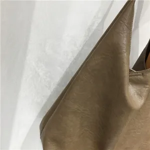 Close-up detail of textured soft leather shoulder tote bag showing fine material and stitching.