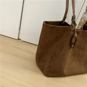Brown suede tote bag close up, soft texture fabric, minimalist everyday style detail.