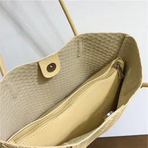 Light yellow woven tote bag interior detail, casual shoulder bag with zipper pocket and snap.
