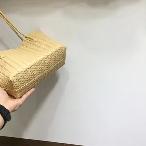 Detailed view of the light yellow woven leather tote bag highlighting soft texture.