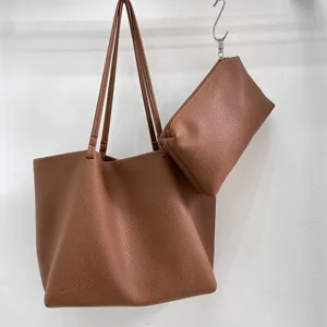 Detail shot of the brown soft PU leather tote bag with matching pouch, simple minimalist design.