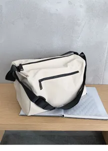 Detailed view of a minimalist off-white canvas messenger bag with black strap and zippers.