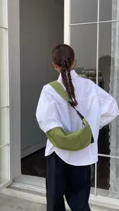 Detail shot of the green crescent shoulder bag, casual moon bag worn by model daily.