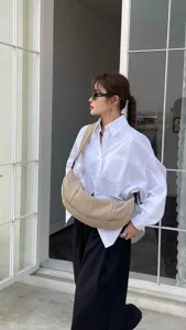 Minimalist casual crescent shoulder bag detail view worn by model, stylish retro design.