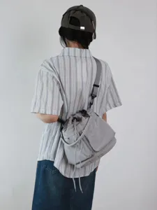 Vista dettagliata della borsa a secchiello casual in grigio nylon indossata sulla schiena.