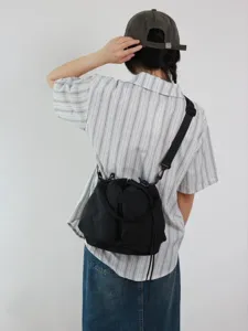 Borsa a secchiello nera in oxford multifunzionale indossata come tracolla casual per l'estate.