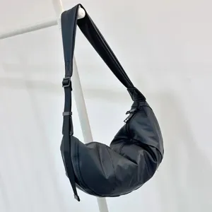 Close-up view of the minimalist black nylon crescent shoulder bag hanging on rack.
