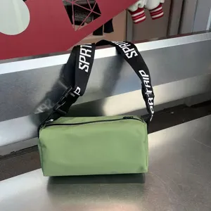 Green cylindrical waterproof crossbody bag with wide letter-printed strap for casual daily wear.