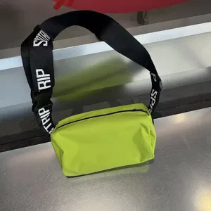 Waterproof coated green crossbody bag with wide black letter strap for casual daily wear detail.