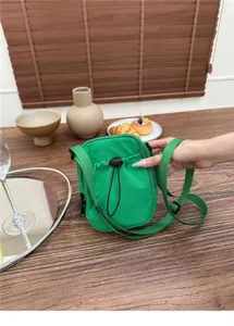 Detail view of a minimalist green nylon crossbody phone bag with casual style and strap.