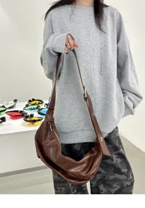 Detailed view of brown oil wax leather shoulder bag, vintage soft crossbody dumpling bag.
