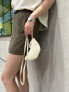 Soft leather croissant bag detail showing half-moon dumpling shape with long strap for vintage style.