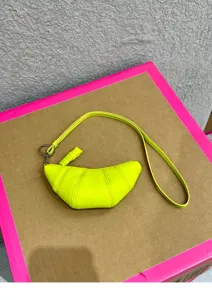 Neon yellow croissant crescent crossbody bag, soft leather mini dumpling purse with strap.
