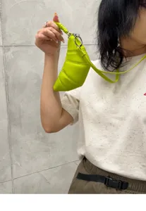Detailed close-up view of a bright green soft leather crescent croissant dumpling mini bag.