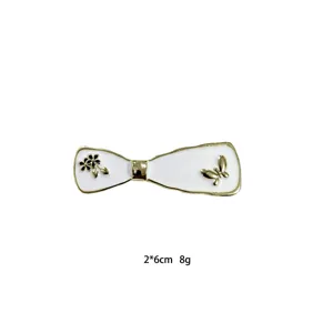 Elegant white and gold bow hair clip with flower and butterfly details for women.