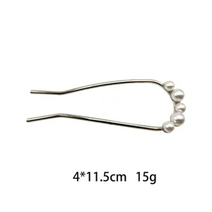 Close-up view of the metal U-shaped hair fork decorated with elegant white faux pearls.