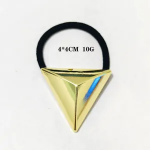 Detailaufnahme des geometrischen Dreieck-Metall-Haargummis, hellgoldene Legierung und Band.